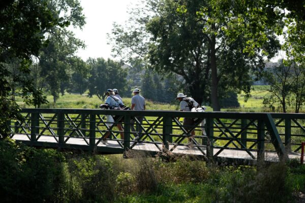 Golfers walk across a bridge during The Pinnacle Bank Championship