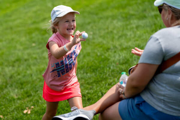 A young fan shows a family member a ball she was gifted during The Pinnacle Bank Championship