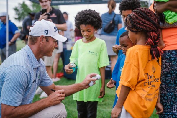 Golfer handing out balls to kids