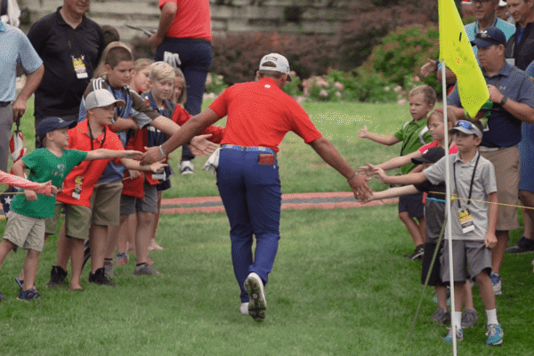 Golfer giving out high fives to onlookers